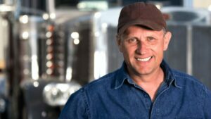 Business owner happy to be qualifying for trucking business loans requires understanding and meeting specific lender requirements.