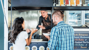 Picture of food truck operator who understands that financing is essential for food truck businesses to cover various expenses, maintain working capital, and seize opportunities for growth. Without it, businesses may struggle to survive and thrive in this competitive industry.